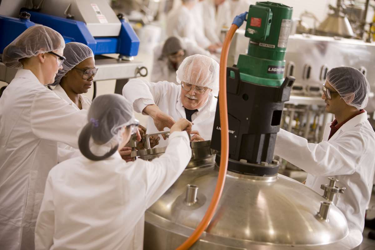 Chemists with protective hair net working around device
